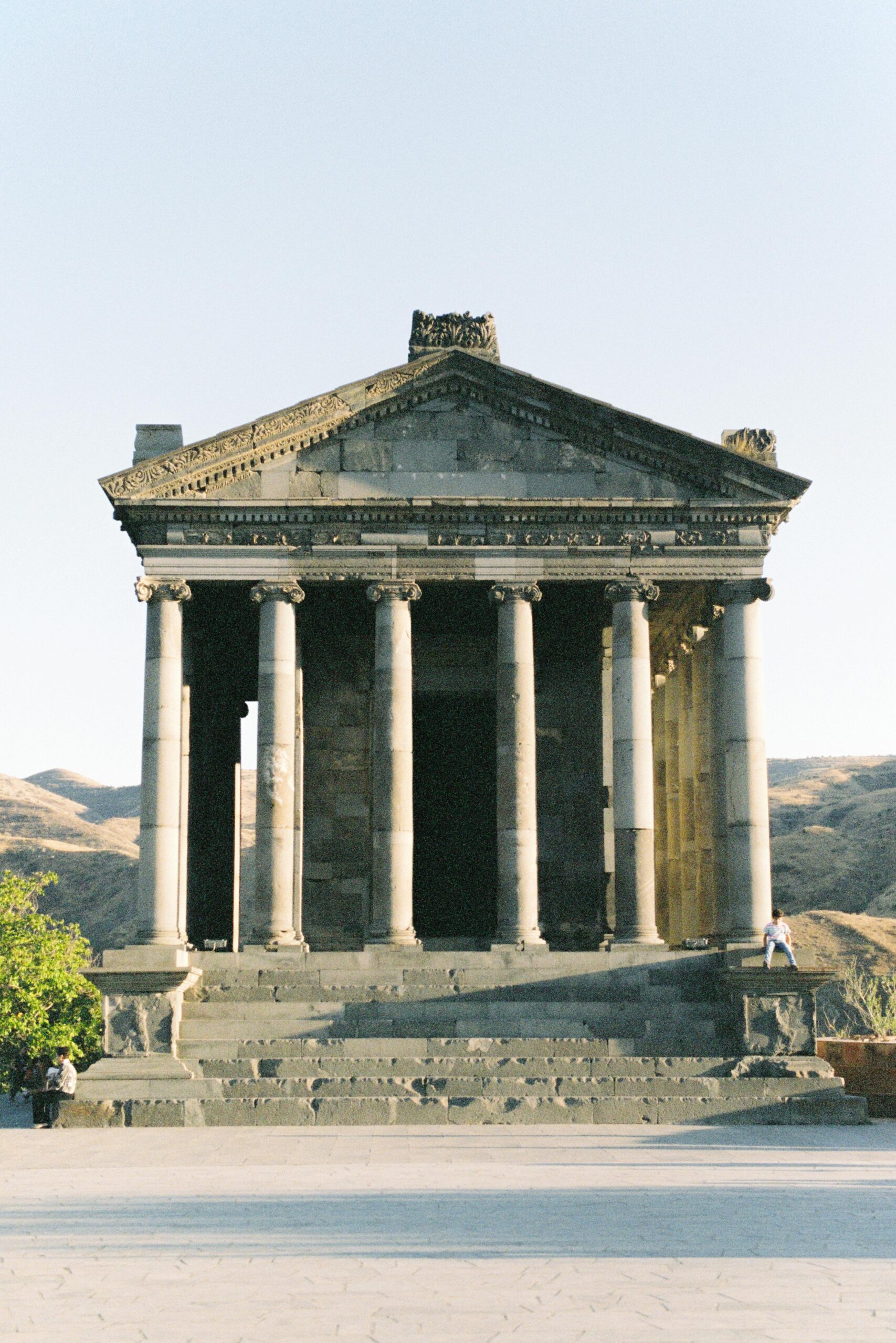 The iconic Temple of Garni, a classical landmark in Armenia, under blue skies.