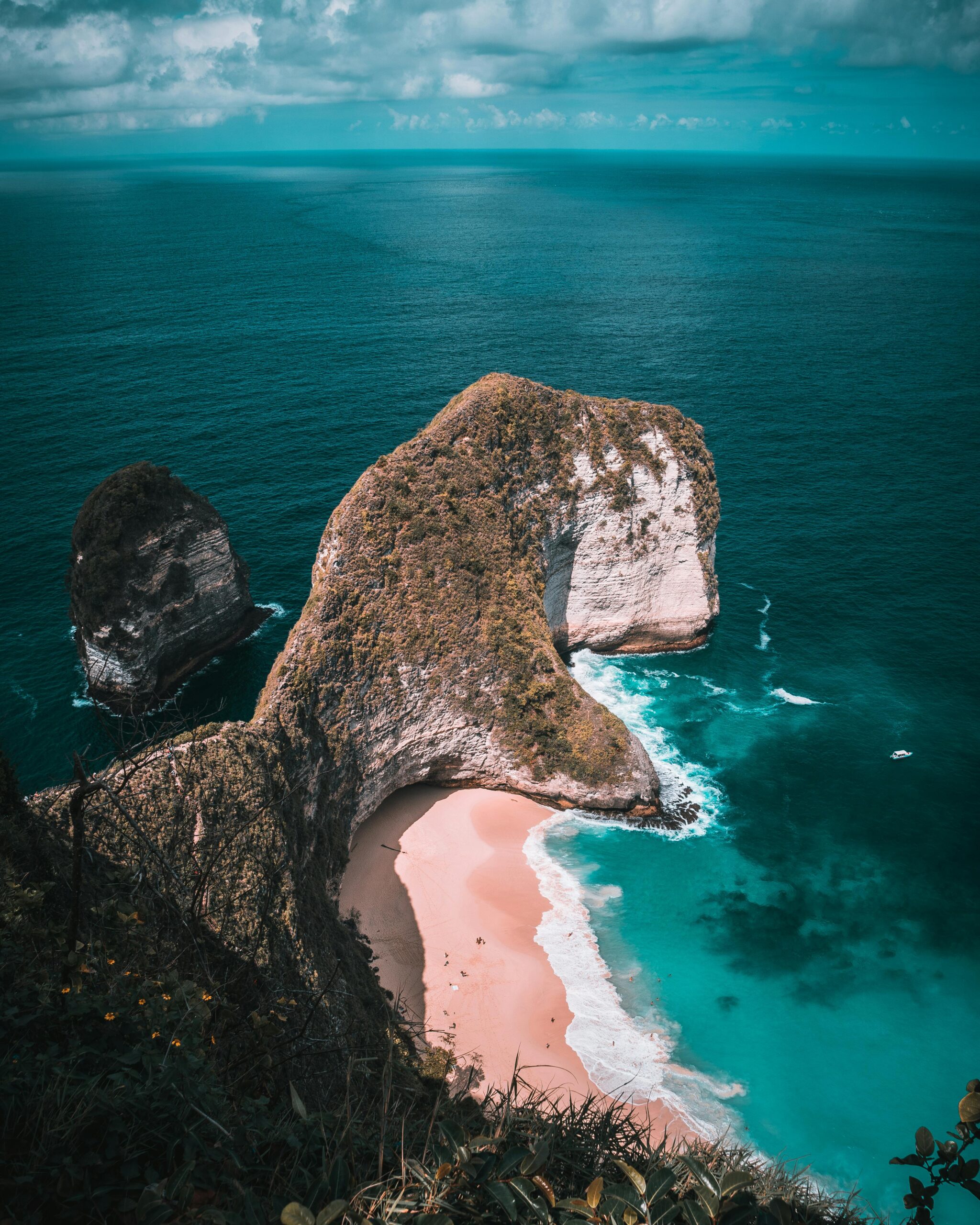 Breathtaking aerial shot of Kelingking Beach in Bali, showcasing turquoise waters and cliffs.