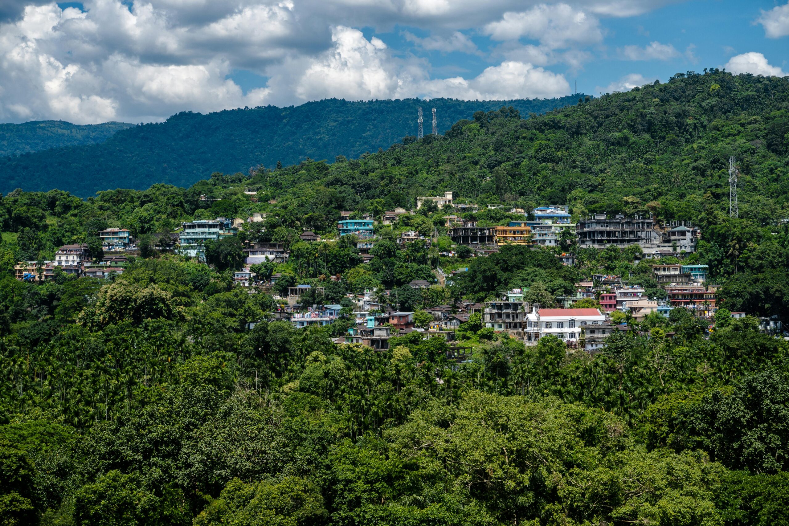 A captivating aerial view of Dawki town nestled in lush greenery and hills, Meghalaya, India.